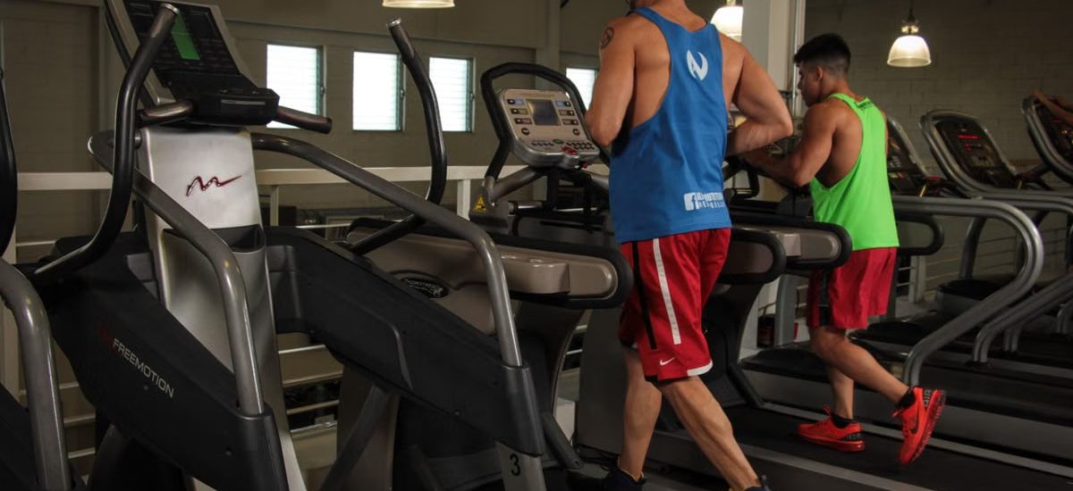Two men running on treadmills in a modern gym, promoting fitness and health.